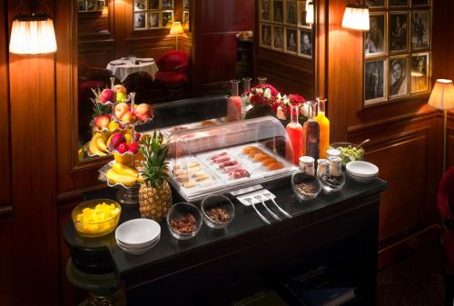 um buffet num quarto de hotel com comida numa mesa em Maison Athénée em Paris