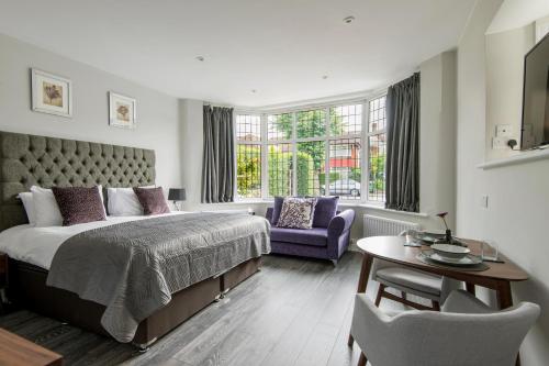 ロンドンにあるM-Hotels Apartmentsのベッドルーム1室(ベッド1台、椅子、テーブル付)