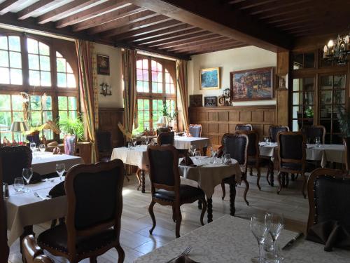 une salle à manger avec tables, chaises et fenêtres dans l'établissement Hôtel Le Sauvage, à Tournus