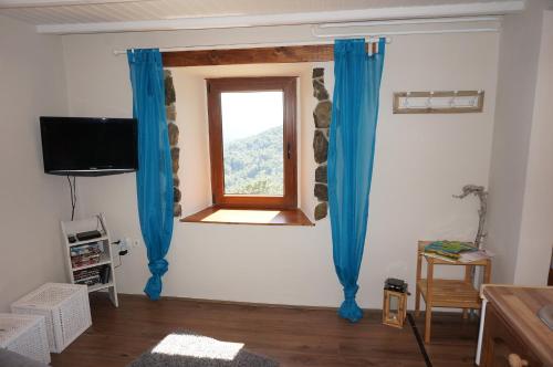 a living room with blue curtains and a window at Valley View Apartment in Kambreško