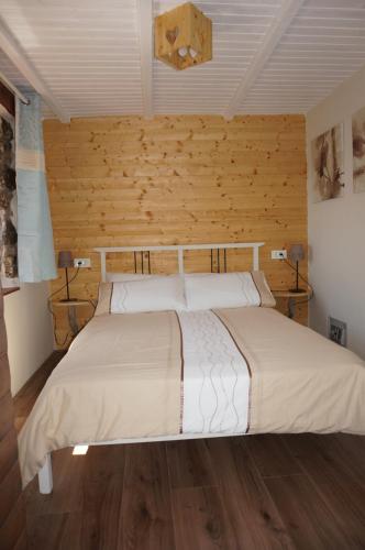 a bedroom with a large bed with wooden walls at Valley View Apartment in Kambreško