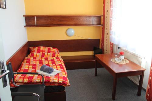 um pequeno quarto com uma cama e uma mesa em Hotel Rambousek em Nové Město nad Metují