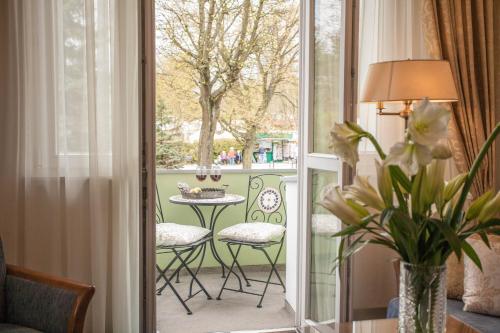 a room with a balcony with a table and chairs at Apartamenty Villa Artis in Świnoujście