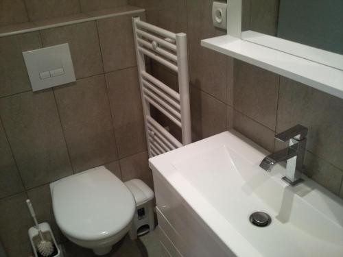 une salle de bain avec des toilettes blanches et un lavabo dans l'établissement Studio Paris tour Eiffel, à Paris