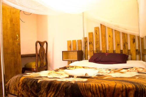 a bedroom with a bed with a wooden head board at Okla GuestHouse in Kampala