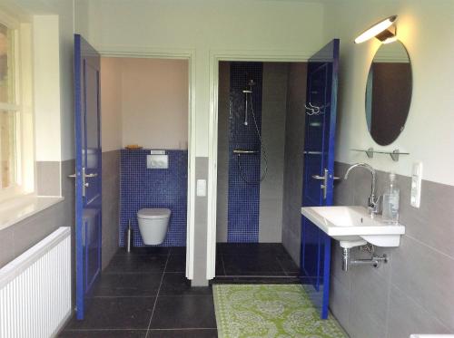 a bathroom with a toilet and a sink and a shower at B&B De Sprokkeltuin in Beuningen