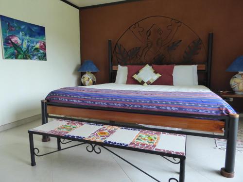 a bedroom with a large bed with a wooden headboard at Lucky Bug Bed And Breakfast in Nuevo Arenal