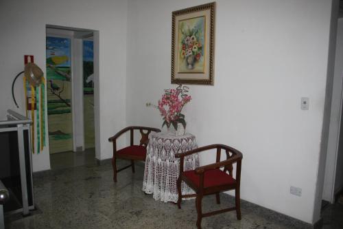 a table with two chairs and a vase of flowers on it at Hotel Marajoara in Belém