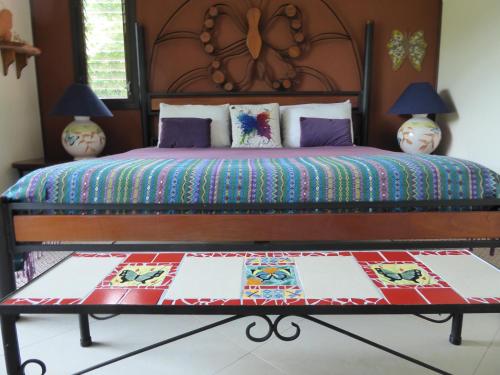 a bedroom with a bed with a colorful quilt on it at Lucky Bug Bed And Breakfast in Nuevo Arenal