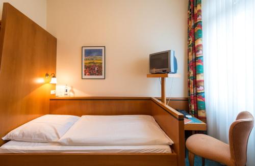 a hotel room with a bed and a television at Hotel Eisbach in Ransbach-Baumbach