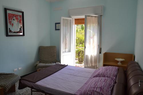 ディアーノ・カステッロにあるLa casa del Prussianoのベッドルーム1室(ベッド1台、椅子1脚、ドア付)