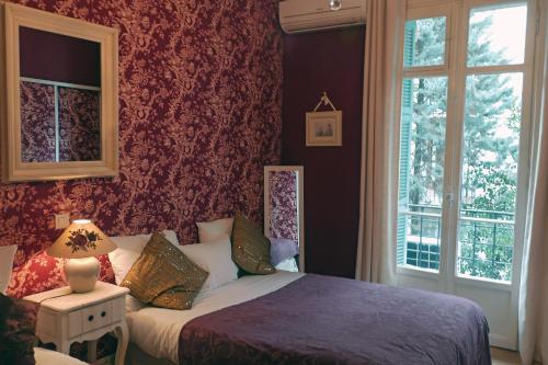 a bedroom with a bed and a window at Hotel Villa Rivoli in Nice