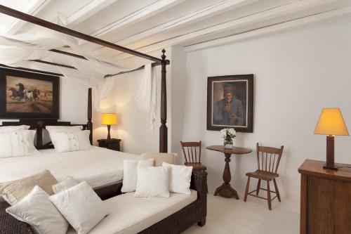 a bedroom with a large bed and a couch at Beachfront Mykonos Guest House in Ornos