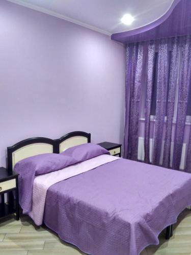 a bedroom with a purple bed and purple curtains at Mini-hotel in Uman