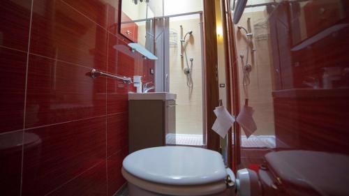 a small bathroom with a toilet and a shower at Red Orange Catania Ognina in Catania