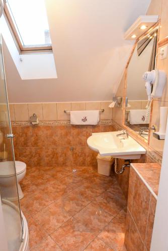 a bathroom with a sink and a toilet at Tinódi Fogadó in Sárvár