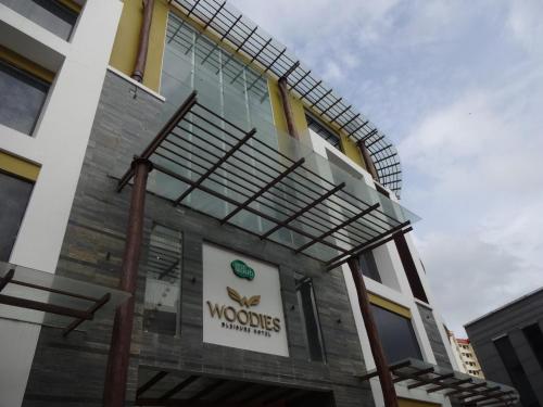 a building with a sign on the side of it at Woodies Bleisure Hotel in Kozhikode
