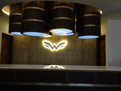 a bar with a sign on the wall of a restaurant at Woodies Bleisure Hotel in Kozhikode