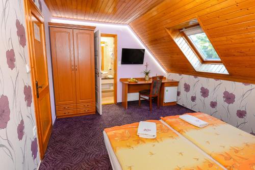 a room with two beds and a desk and a window at Tinódi Fogadó in Sárvár