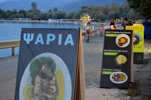two signs on the beach with food on it at Dimitropoulos Apartments in Eleonas
