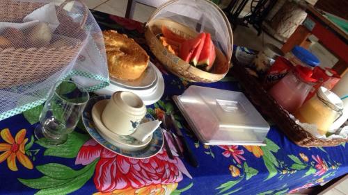 een tafel met een dienblad en een fruitschaal bij Pousada Nativo's in Nova Almeida