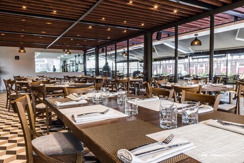 Un restaurante con mesas y sillas de madera y ventanas. en Domingo Santo Hotel Boutique, en Ciudad de México