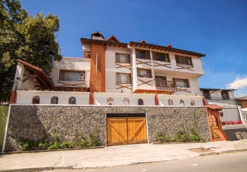 a house with a yellow door on a stone wall at Apartamentos Los Quipus in Quito
