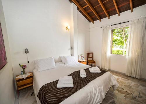 a bedroom with a large bed with towels on it at El Lugar Boutique Hotel in Pereira