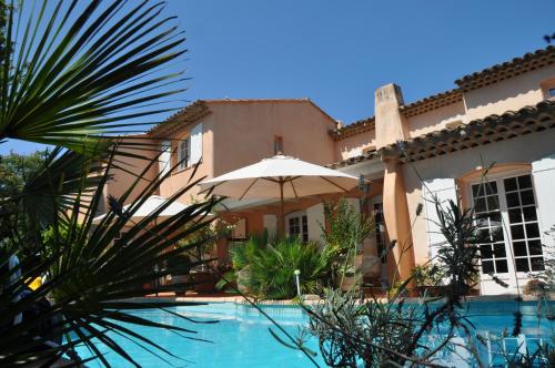 une maison avec une piscine et un parasol dans l'établissement La Villa Rosalie, à Ventabren