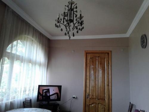 a bedroom with a chandelier and a window and a door at House Anna in Gonio