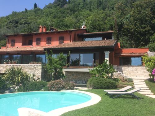 una casa con piscina frente a una casa en Energaia, en Toscolano Maderno