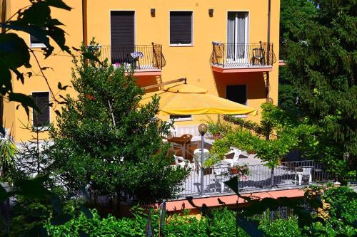 żółty budynek ze stołem i parasolem przed nim w obiekcie Albergo Di Piero w mieście Caramanico Terme