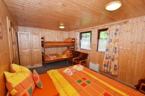 ein Schlafzimmer mit einem Bett und einem Stuhl in einem Zimmer in der Unterkunft Lesní pension in Lipno nad Vltavou