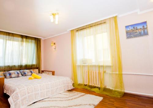 Un dormitorio con una cama con un pato amarillo. en RENT-сервис Apartment Irtyshskaya Naberezhnaya 29 en Omsk