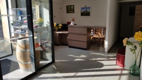 a room with a glass door and a kitchen at Auberge de Marville in Marville