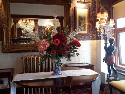a vase of flowers on a table in a room at The Lonsdale in Blackpool