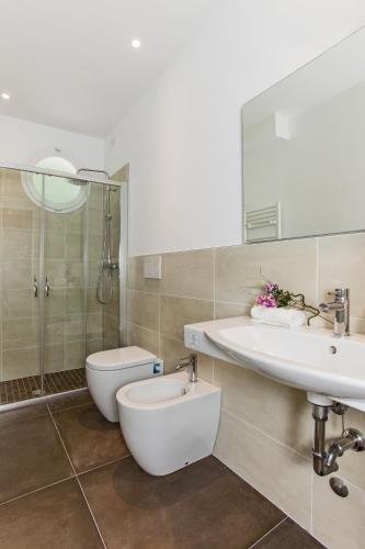 a bathroom with a toilet and a sink and a shower at Hotel Houston Suites in Rimini