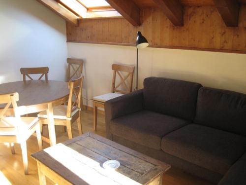 sala de estar con sofá y mesa en La Buhardilla De Isavarre, en Isavarre