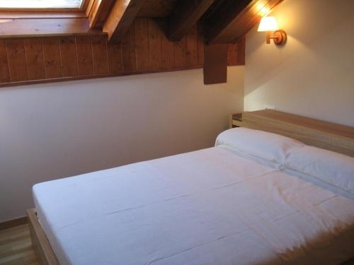 a bedroom with a white bed and a window at La Buhardilla De Isavarre in Isavarre