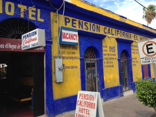 a yellow and blue building with signs on it at Pension California in La Paz
