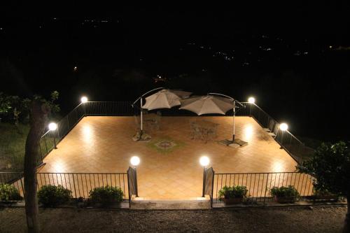 a patio with an umbrella and lights at night at B&B La Residenza Torchiara in Torchiara