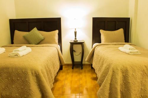 two beds with towels on them in a room at Hotel & Restaurant Fleur de Lis in Concepción de Ataco