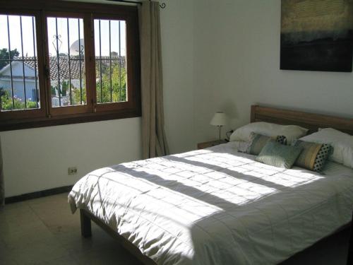 una camera da letto con un grande letto e una finestra di Villa Maria de Waard a Nerja