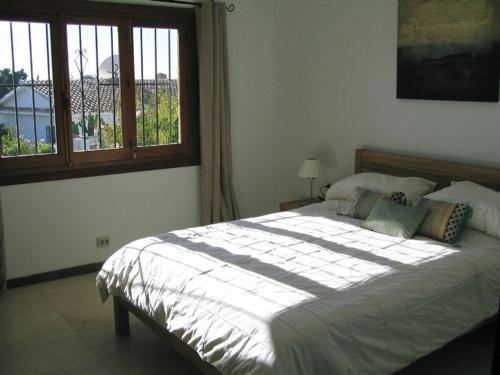 a bedroom with a large bed with a window at Villa Maria de Waard in Nerja