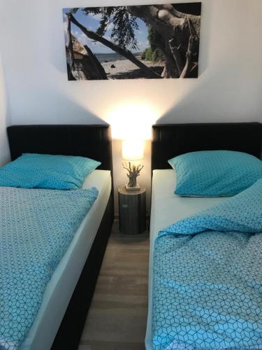 ザスニッツにあるAppartement Seemeile 1の青い枕が備わる客室内のベッド2台