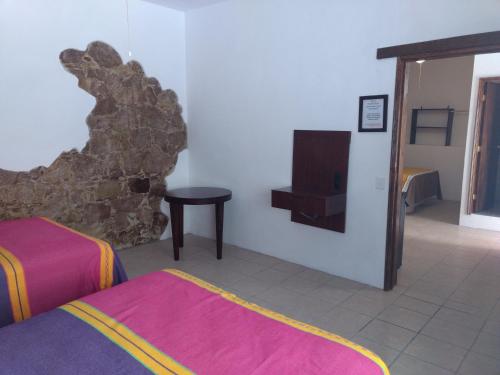 a room with a bed and a tv in it at Hotel Hacienda Morales. in Guanajuato