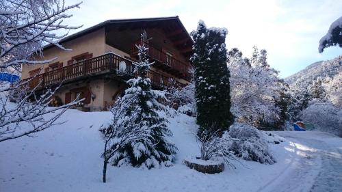ein Haus im Schnee mit einem Weihnachtsbaum in der Unterkunft appartement indépendant chalet "les Ormes" in Enchastrayes