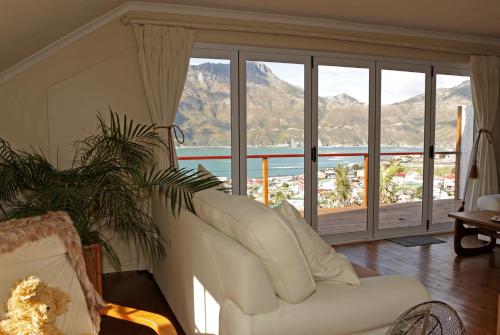 a living room with a white couch and a large window at The Loft in Hout Bay