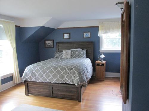 a bedroom with a bed with a blue wall at Burnbrae Farm & Paradise Inn in Bridgetown