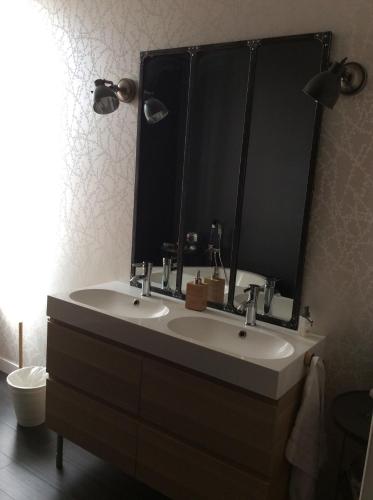 uma casa de banho com um lavatório e um espelho grande em Maison (villa) de charme avec piscine em Carbon-Blanc